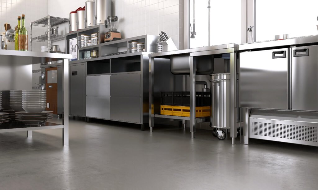 New, clean gray concrete resin vinyl floor in commercial, professional bakery restaurant kitchen, stainless steel cabinet, sink, trash bin, machine, equipment. Industrial interior design background 3D Commercial Kitchen Floor Coatings